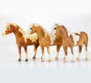 Three brown and white Breyer models in a row