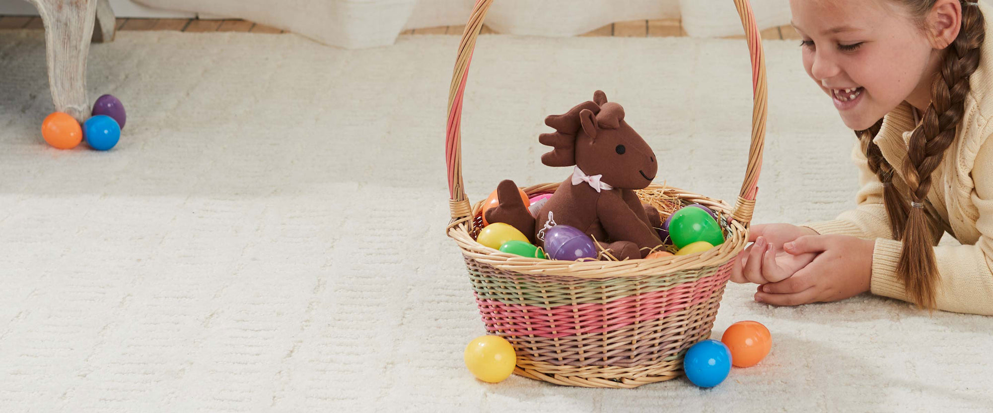 Meet Candy - Breyer's 2025 Easter Plush in a basket on a floor next to a child