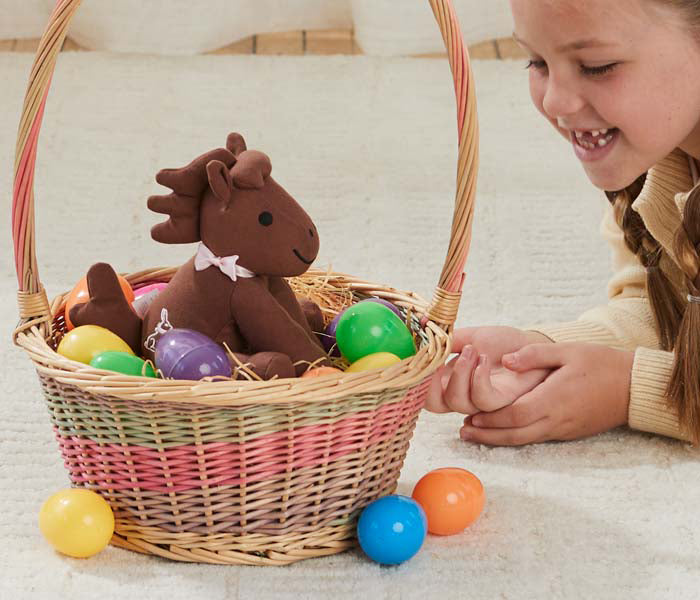 Meet Candy - Breyer's 2025 Easter Plush in a basket on a floor next to a child