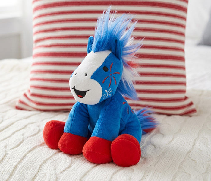 Boom | 2026 Americana Plush sitting on a bed