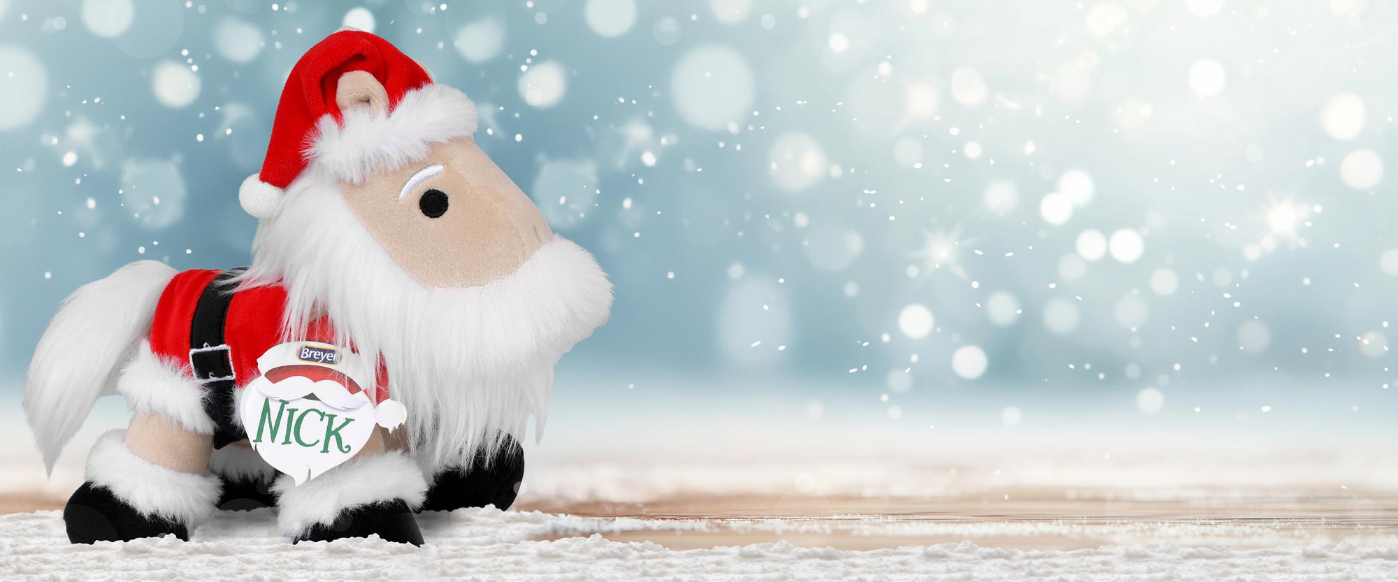 Nick - The 2025 Holiday Plush in a snowy setting.