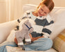 A child holding the 11" Grey Horse | Bridle Buddies sitting o a couch