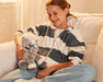 A child holding the 11" Grey Horse | Bridle Buddies sitting on a couch