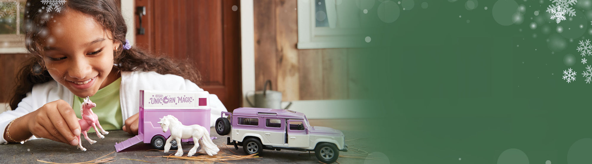A child playing with a Breyer vehicle on a table