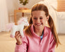 A child holding up the 7" Unicorn | Whinny Bits in front of a couch