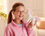 A child smiling and holding up the 7" Unicorn | Whinny Bits in front of a couch
