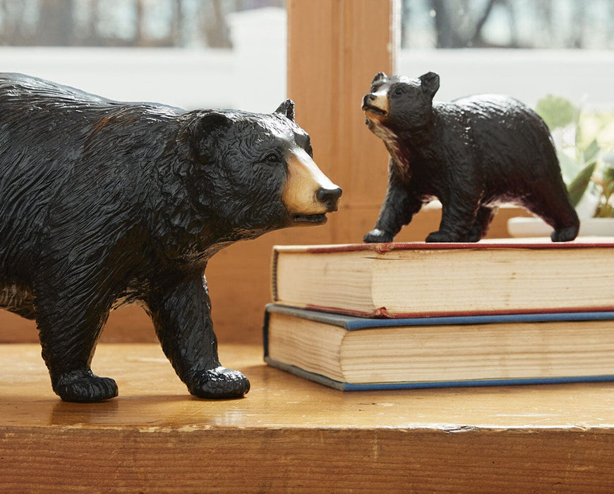Breyer's Traditional Black Bear and Cub set standing on a table with books.