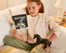 A child with the Black Beauty Horse & Book Set - reading on a couch