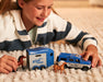 A child playing with the Breyer Farms™ Land Rover® and Tag-A-Long Horse Trailer on the floor