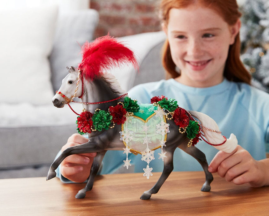 A child playing with the Christmas in Bloom | 2025 Holiday Horse on a table