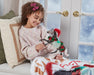 a child playing with the Christmas in Bloom | 2025 Holiday Horse on a chair