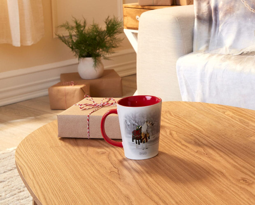 Holiday Homecoming Mug on a table with a holiday package