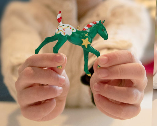 Someone holding up a finished Paint Your Own Horse | 2026 Ornament Craft Kit