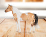 Stablemates Singles Six-Piece Assortment | Series 3 - Warmblood model standing on a wooden table with a window in the background
