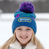 A girl wearing the Breyer Blue Pom-Pom Winter Hat