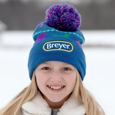 A girl wearing the Breyer Blue Pom-Pom Winter Hat